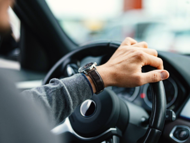 Мужчина сидит за рудем автомобиля